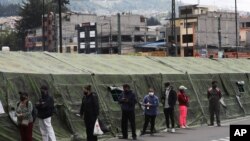 Familias de pacientes con el COVID-19, esperan a las afueras del hospital del Instituto de Seguridad Social en Quito, la capital, el 19 de enero de 2021.