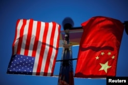 Bendera Amerika Serikat dan AS berkibar di tiang lampu di kawasan Pecinan Boston, Massachusetts, AS, 1 November 2021. (Foto: Reuters)