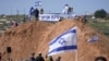 Pemukim Israel berkumpul dalam sebuah rally untuk mendukung pendirian kembali pos terdepan ilegal Eviatar dekat kota Nablus di Tepi Barat, Jumat, 18 Februari 2022. (Foto: AP)