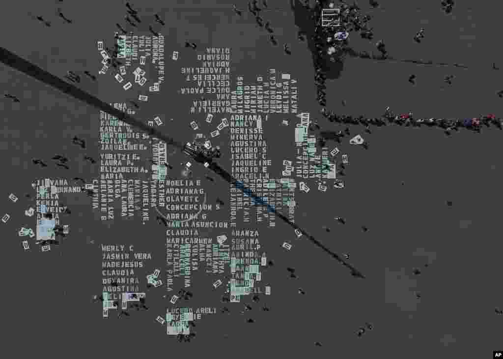 Women work on painting the names of more than 3,000 victims of femicide on Mexico City&#39;s main plaza, The Zocalo, on International Women&#39;s Day, March 8, 2020.