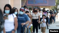 Una línea de personas espera para someterse a sus niños a una prueba de COVID-19 con vistas al regreso a clases en Los Ángeles, California, el 12 de agosto de 2021.