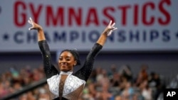FILE - Simone Biles celebrates after competing in the vault during the U.S. Gymnastics Championships in Fort Worth, Texas. June 6, 2021. The top-ranked female gymnast is a medal favorite at the Tokyo Olympics.