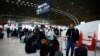 Passengers wait in front of the desk of Air France at the Roissy Charles de Gaulle airport, north of Paris, March 12, 2020.