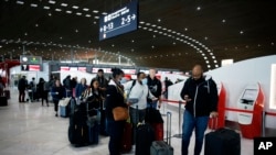 Passengers wait in front of the desk of Air France at the Roissy Charles de Gaulle airport, north of Paris, March 12, 2020.