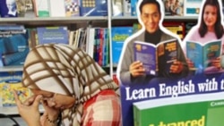 A Malaysian woman reads at a book fair in Kuala Lumpur