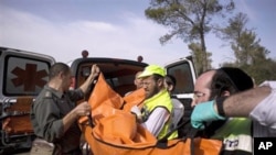 Israeli rescue workers carry the body of US tourist Christine Logan after she was found in a wooded area near the village of Mata, outside Jerusalem, 19 Dec 2010