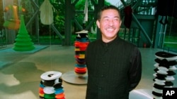 FILE - Japanese fashion designer Issey Miyake smiles while inaugurating the exhibition "Making Things" in Paris on Oct. 11, 1998.
