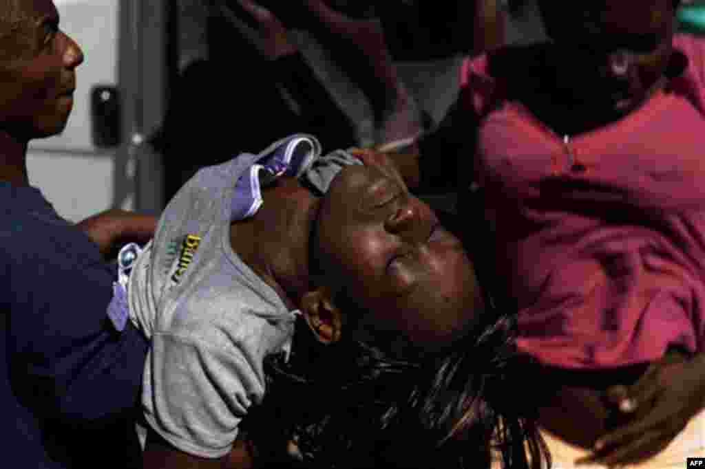 A woman suffering cholera symptoms is carried to St. Catherine hospital, run by Doctors Without Borders, in the slum of Cite Soleil in Port-au-Prince, Haiti, Wednesday Nov. 17, 2010. A month-old cholera epidemic has killed at least 1,000 people and hospit