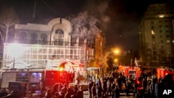 Smoke rises as Iranian protesters set fire to the Saudi Embassy in Tehran, Sunday, Jan. 3, 2016. Protesters upset over the execution of a Shi'ite cleric in Saudi Arabia set fires to the Saudi embassy in Tehran.