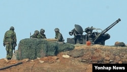 북한이 정전협정 백지화를 선언하고 위협 수위를 높이는 가운데, 13일 오전 한국 연평도 초소에서 해병대원들이 경계작전을 펼치고 있다.