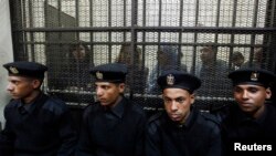 Des accusés dans un box lors d'un procés dans un tribunal du Caire, 26 février 2012.