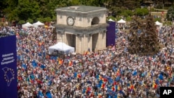 People holding European Union and Moldovan flags fill the Great National Assembly Square in Chisinau, Moldova, Sunday, May 21, 2023, at the end of a rally called by President Maia Sandu, aiming to show the country's support for EU membership. (AP Photo/Aurel Obreja)