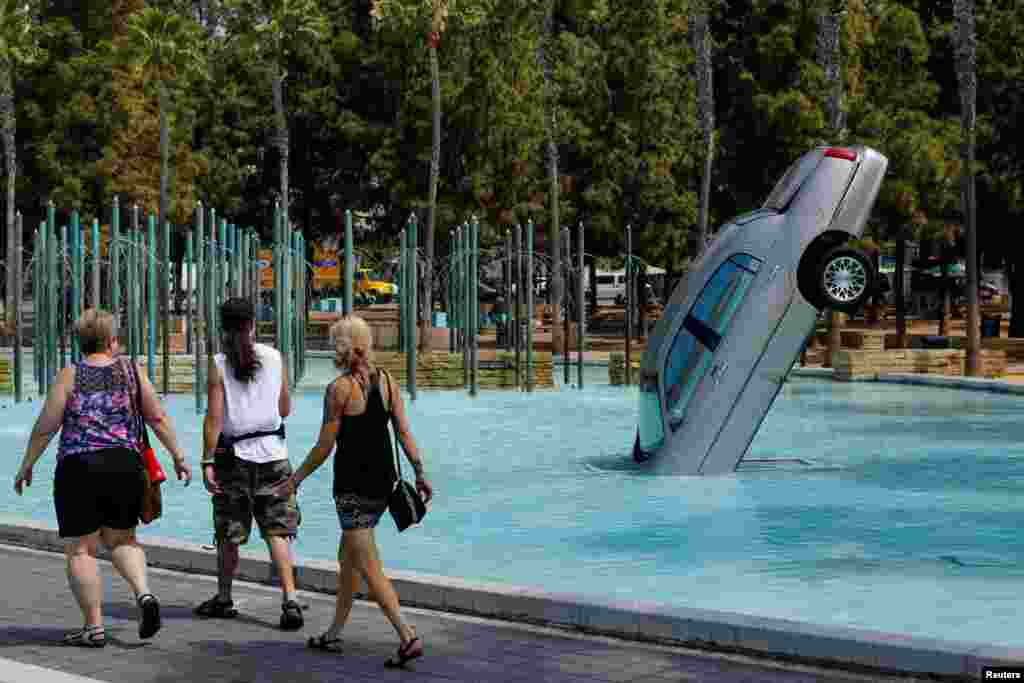 People walk past part of an outdoor display as preparations continue for the upcoming pop culture convention Comic Con in San Diego, California, July 17, 2018.