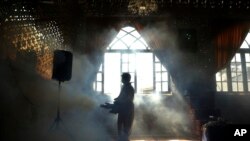 A firefighter disinfects the shrine of Saint Saleh to help prevent the spread of the new coronavirus in northern Tehran, Iran, March, 6, 2020. 