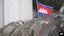 Bendera Nasional Kamboja berkibar di atas kawat berduri di Phnom Penh, Kamboja. (Foto: AP)