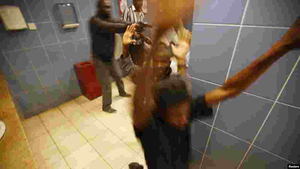 Armed police search customers taking cover inside a bathroom while combing through the Westgate Shopping Mall for gunmen in Nairobi, September 21, 2013.