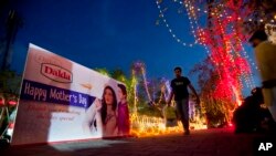 A man walks on a footpath decorated with lights and billboard by workers capital development authorities to observe International mother's day celebration in Islamabad, Pakistan, May 7, 2016. 