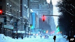 Pedestrians walk along Central Park West in New York Monday after a blizzard hammered the city and much of the Northeast, 27 Dec 2010