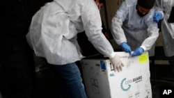 Medics open a box of the Russian Sputnik V coronavirus vaccines inside a truck at the Kerem Shalom border crossing, in Rafah, Gaza Strip, Feb. 17, 2021. 