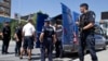 FILE - Kosovo police officers escort a Kosovo Albanian man suspected of fighting alongside Islamic radicals in Iraq and Syria to a local court in Pristina, Aug. 12, 2014. A report has found that found that Kosovar women are more likely to be recruited into violent extremist organizations by family members, rather than join for religious reasons.