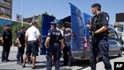 FILE - Kosovo police officers escort a Kosovo Albanian man suspected of fighting alongside Islamic radicals in Iraq and Syria to a local court in Pristina, Aug. 12, 2014. A report has found that found that Kosovar women are more likely to be recruited into violent extremist organizations by family members, rather than join for religious reasons.