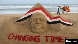 A man with his camel walks near a sand sculpture of Egypt's ousted president Mohamed Morsi created by Indian sand artist Sudarshan Patnaik at the golden sea beach in Puri, about 65 km (40 miles) from the eastern Indian city Bhubaneswar July 5, 2013.