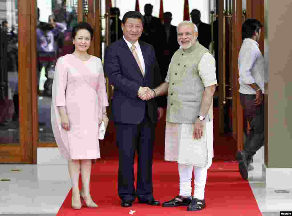 India&#39;s Prime Minister Narendra Modi (right) and China&#39;s President Xi Jinping&nbsp;shake hands as Xi&#39;s wife Peng Liyuan looks on before their meeting in the western Indian city of Ahmedabad, Sept.&nbsp;17, 2014.&nbsp; 