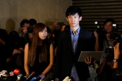 FILE - Democratically elected legislators Yau Wai-ching, left, and Baggio Leung meet journalists outside the High Court after the court disqualified them from taking office as lawmakers in Hong Kong, Nov. 15, 2016.