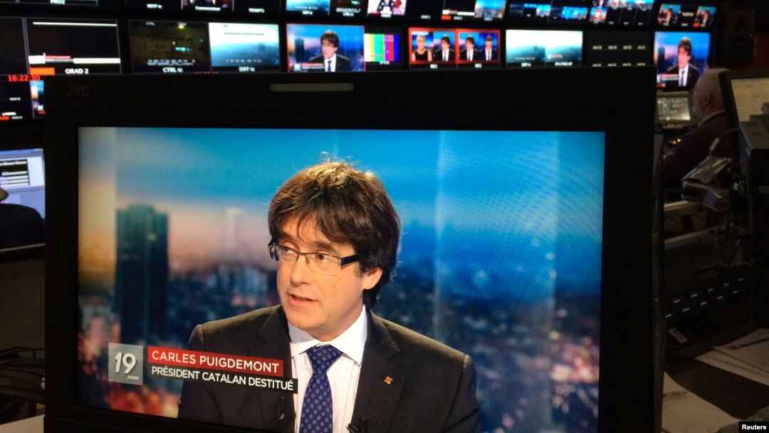 Presiden Catalonia yang digulingkan, Carles Puigdemont tampil pada layar televisi saat wawancara langsung di sebuah bar di Brussels, Belgia, 3 November 2017.