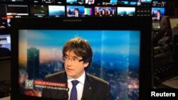 Presiden Catalonia yang digulingkan, Carles Puigdemont tampil pada layar televisi saat wawancara langsung di sebuah bar di Brussels, Belgia, 3 November 2017.