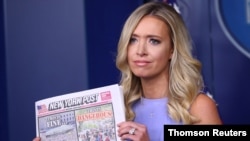 La portavoz de la Casa Blanca, Kayleigh McEnany, muestra a los periodistas una portada del diario New York Post que tilda de "hipocresía" las críticas recibidas por el presidente Donald Trump por organizar un mitin electoral en medio de la campaña.