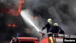 Firemen try to extinguish a fire at Great Nigeria Insurance House in Lagos business district November 4, 2013. There have been no casualties reported, and the cause of the fire is as yet unknown. REUTERS/Akintunde Akinleye (NIGERIA - Tags: DI