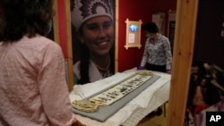 Co-curator Jo Loosemore, right, and Kate Johnson, Exhibitions Office Plymouth, prepare a recently created wampum belt made by members of the Wampanoag Native America people, to put on display in Southampton, England, Aug. 13, 2020. 