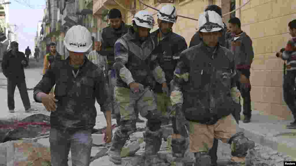 Rescuers walk on the rubble of collapsed buildings after what activists said was an airstrike by forces loyal to Syrian President Bashar al-Assad in Aleppo, Feb. 14, 2014. 