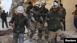 Rescuers walk on the rubble of collapsed buildings after what activists said was an airstrike by forces loyal to Syrian President Bashar al-Assad in Aleppo, Feb. 14, 2014. 