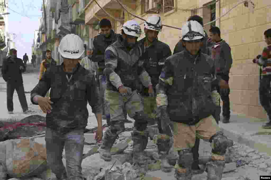 Rescuers walk on the rubble of collapsed buildings after what activists said was an airstrike by forces loyal to Syrian President Bashar al-Assad in Aleppo, Feb. 14, 2014. 