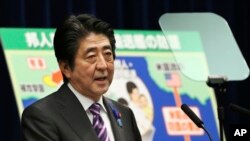 FILE - Japanese Prime Minister Shinzo Abe speaks during a press conference at his official residence in Tokyo, July 1, 2014. 