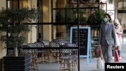 Un hombre, con mascarilla, pasa frente a un restaurante cerrado en París en medio de la pandemia de coronavirus en Francia, el 29 de abril de 2021.