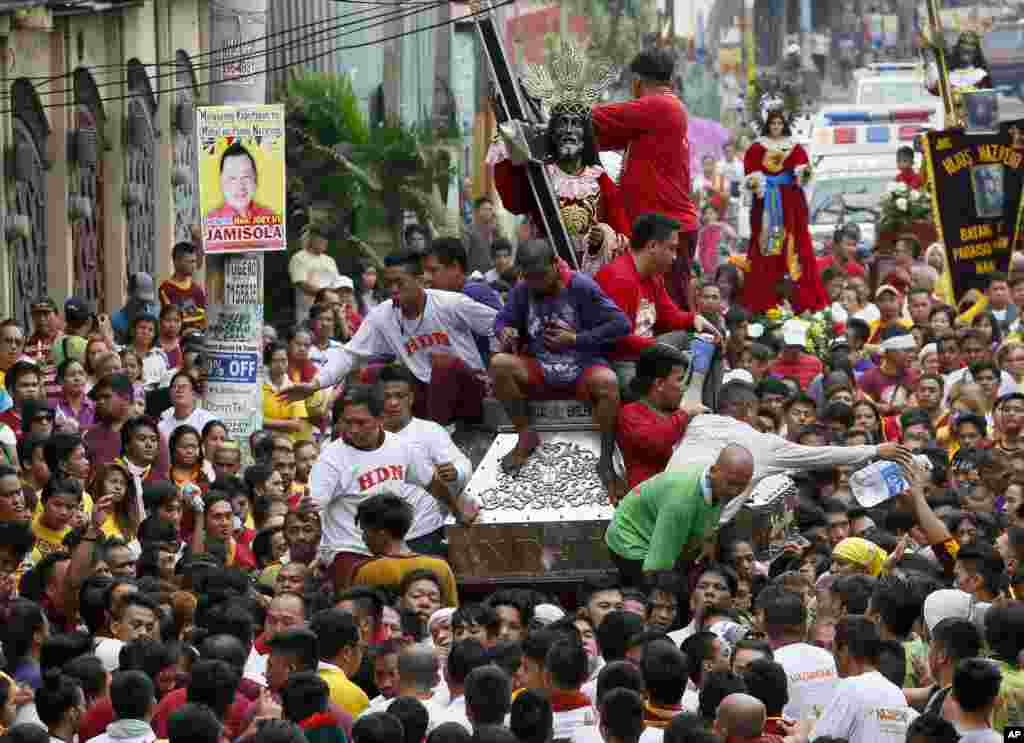 Filipino Catholic devotees jostle to get closer to the image of the Black Nazarene during a procession on New Year&#39;s eve in Manila, Philippines, Dec. 31, 2015.