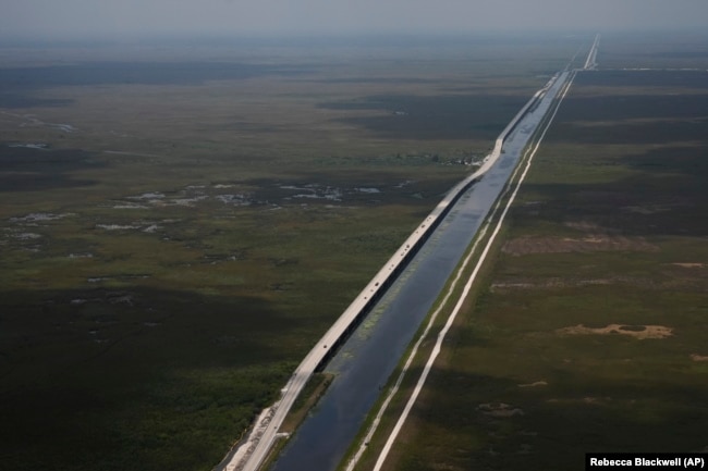 Sections of the Tamiami Trail which have been replaced with bridges to allow water to flow freely into Everglades National Park, at left, are seen from the air in southern Florida, Friday, May 17, 2024.