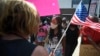 FILE - Pro-mask wearing demonstrator Djenaba Pershay, center, speaks with a non-mask demonstrator, left, at the Cobb County School Board Headquarters during a pro mask wearing protest, in Marietta, Ga., Aug. 12, 2021.