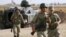 Turkish soldiers walk stand guard on the Turkish-Syrian border near the Akcakale border crossing, southern Sanliurfa province, October 5, 2012. 