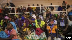 FILE - People displaced from Palma by armed insurgents are seen gathered to receive humanitarian aid, in Pemba, Cabo Delgado province, Mozambique, April 2, 2021.