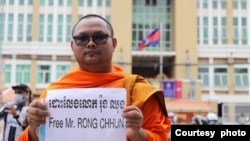 FILE - Activist monk Bor Bet holds a sign reading 'Free Mr. Rong Chhun' in front of Phnom Penh Municipal Court in August 2020. (Photo courtesy Bor Bet)