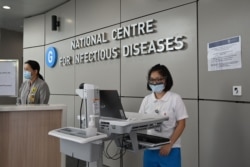 FILE - Medical staff prepare pre-screening procedure at the National Centre for Infectious Diseases building, at Tan Tock Seng Hospital, in Singapore, Jan. 31, 2020.