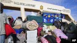 An Egyptian, who has just crossed Salloum land port gate with Libya, at background, takes a nap over his luggage. Thousands of other foreigners were still stranded, February 23, 2011