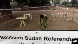 A worker sweeps a polling centre before the opening of the fifth day of the referendum in Juba, south Sudan January 13, 2011