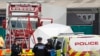 Police officers are on the scene after a truck, in rear, was found to contain a 39 dead bodies, in Thurrock, England, Oct. 23, 2019. 