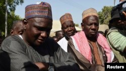 Wasu mutane kennan daga Gwoza, jihar Borno, da tashe-tashen hankula ya raba da gidajensu, suna taro a sansanin ‘yan gudun hijira a lokacin da gwamnan jihar Borno Kashim Shettima (babu hotonshi) a garin Mararaba Madagali, jihar Adamawa. Fabrairu 18, 2014. 