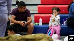 A man sits with his family inside a hurricane evacuation shelter at Fairview Middle School before Hurricane Helene made landfall in Leon County, Florida, Sept. 26, 2024.